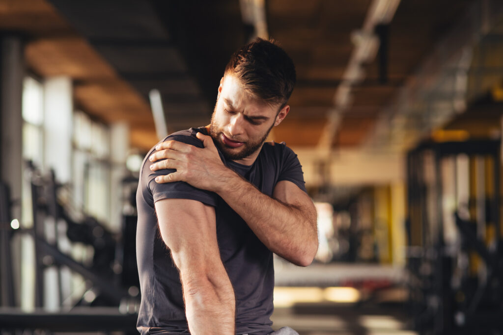 Man with SLAP tear holds his shoulder in pain