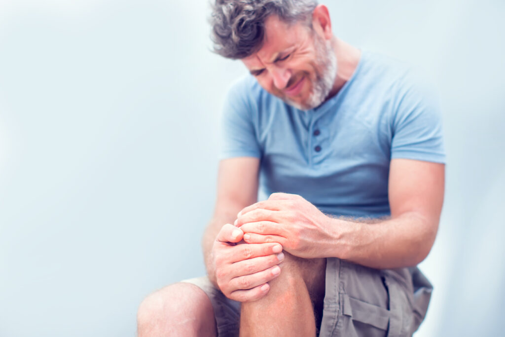 Closeup man hand holding knee with pain on bed, runner's knee