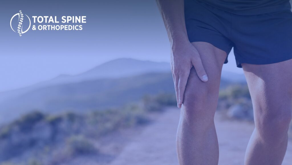 An image of a man holding his knee in pain.
